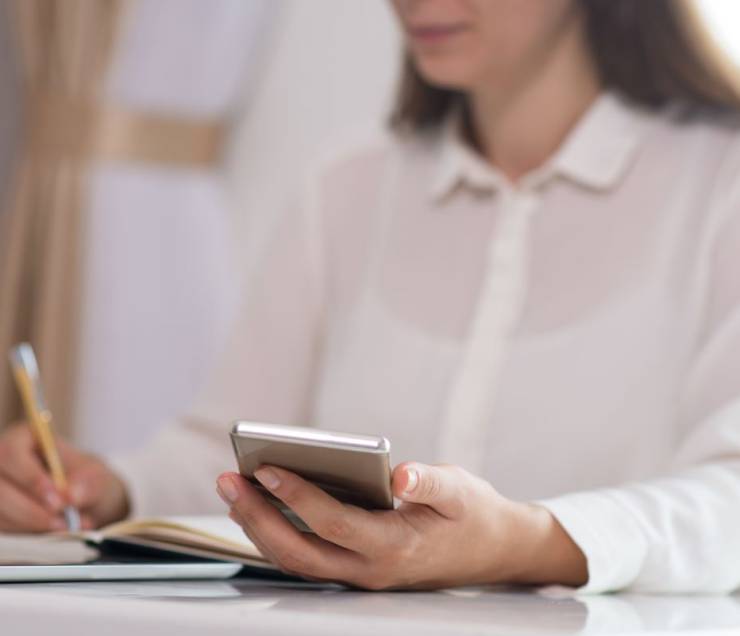 close-up-young-woman-sitting-table-holding-mobile-phone1